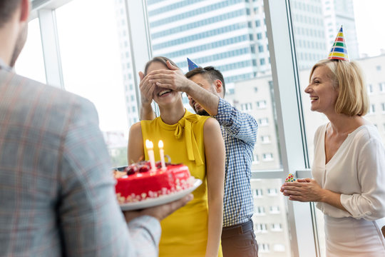 Business people celebrating birthday with cake in office