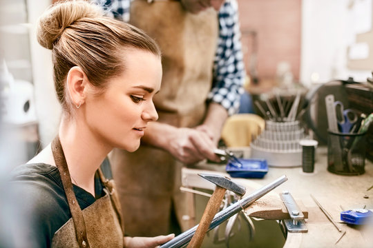 Female jeweler using equipment in workshop