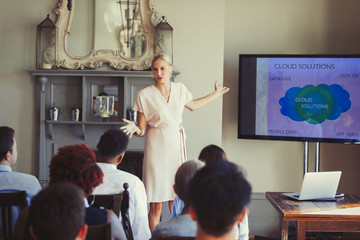 Businesswoman leading conference presentation at television screen