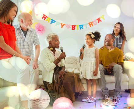 Grandmother granddaughter singing karaoke microphones at birthday party