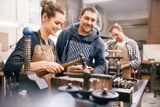 Jewelers using equipment in workshop