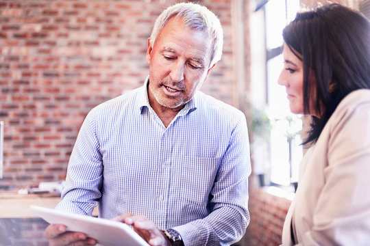 Businessman and businesswoman using digital tablet