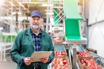 Portrait confident manager clipboard in apple food processing plant