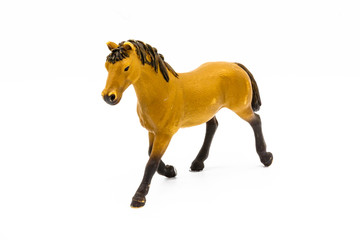 Fototapeta premium Toy brown foal isolated on white. Cute little toy horse isolated on white. Farm animals collection/Toy brown foal isolated on white.