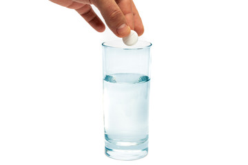 An effervescent aspirin tablet is thrown into a glass of water.