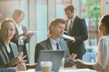 Serious businessman talking to businesswoman in conference room meeting