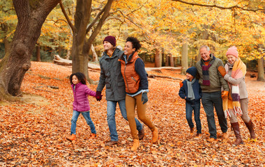 Multi-generation family walking in autumn park