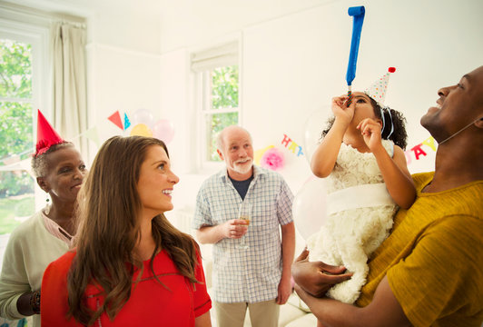 Multi-ethnic family celebrating with party favors