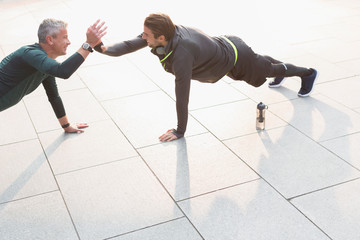 Men doing plank exercises and high-fiving