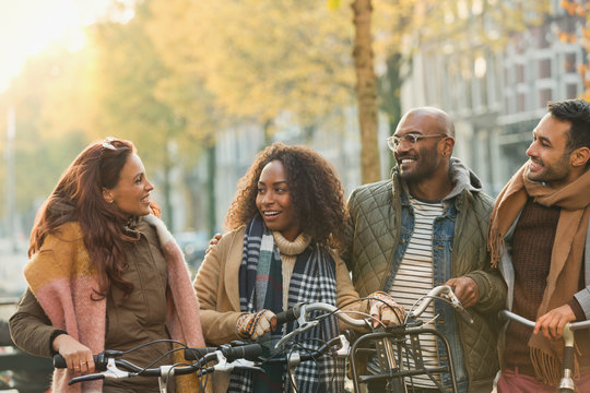 Friends bike riding on urban autumn street