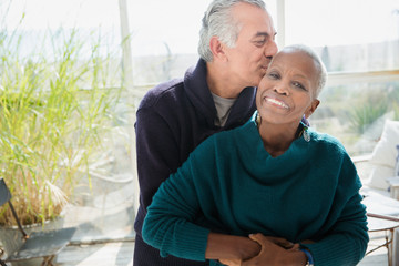 Portrait affectionate senior couple hugging and kissing