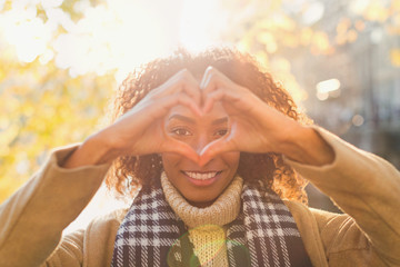 Portrait smiling young woman forming heart-shape with hands