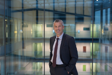 Portrait smiling, confident businessman in modern office atrium
