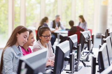 Girl students studying at computer in library