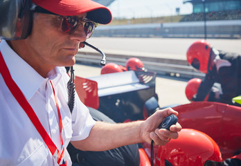 Manager with stopwatch timing formula one pit stop practice session
