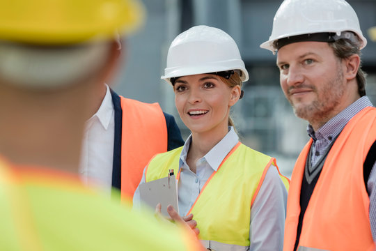 Smiling engineers meeting at construction site