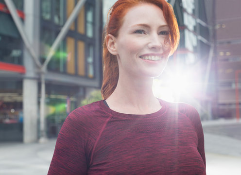 Close up smiling female runner on urban sidewalk