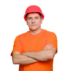Portrait serious handsome worker with folded arms, wearing construction helmet and orange informal t-shirt