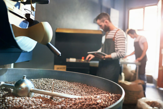 Male coffee roasters behind roasting coffee beans