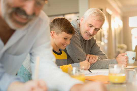 Father helping son with homework at counter