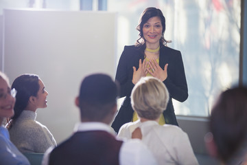 Businesswoman gesturing, leading conference meeting