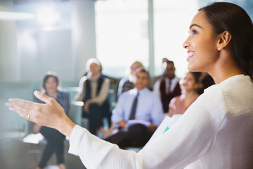 Smiling businesswoman leading conference presentation