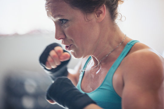 Close up determined, tough female boxer shadowboxing