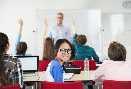 Portrait smiling girl student sitting in classroom during lesson
