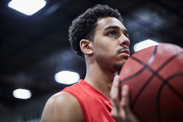 Portrait serious, focused young male basketball player holding basketball