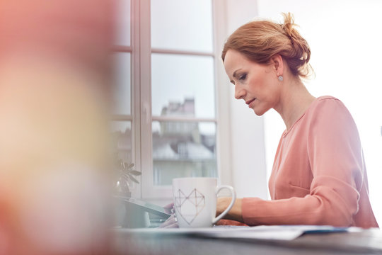Serious, focused businesswoman working at digital tablet