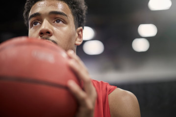 Close up focused young male basketball player holding basketball