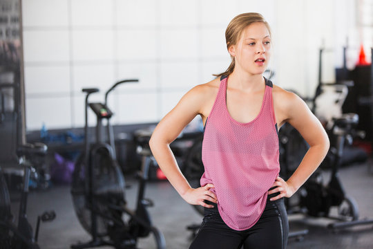 Portrait tired young woman resting post workout at gym