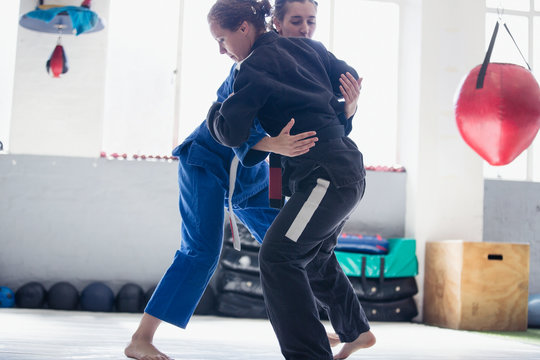 Women practicing judo in gym