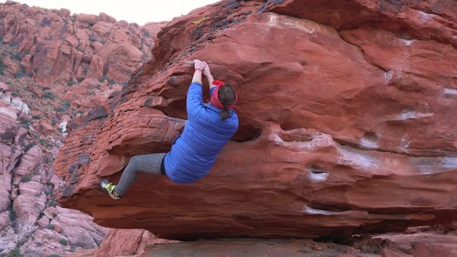 Confident young female climber on a overhanging boulder problem at Red Rock