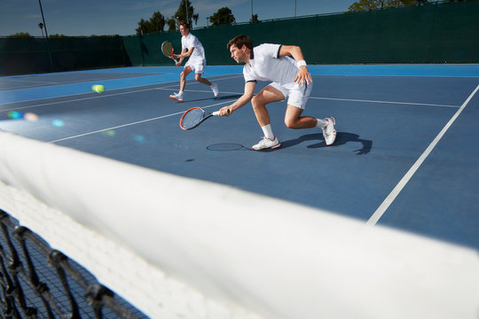 Young male tennis doubles players playing tennis on tennis court