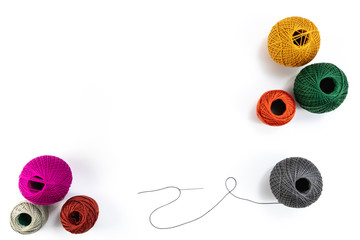 Embroidery accessories. Multicolored bundles of thread, scissors, sewing needles. White background...
