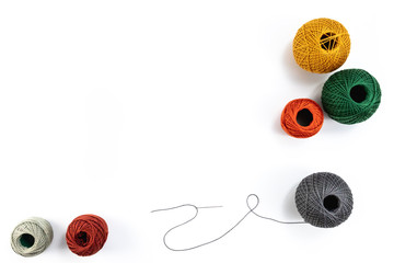 Embroidery accessories. Multicolored bundles of thread, scissors, sewing needles. White background...