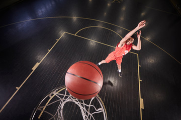 Young male basketball player shooting the ball on court in gymnasium