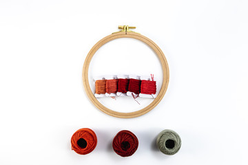 Embroidery accessories. Multicolored bundles of thread, scissors, sewing needles. White background ready for copywriting.