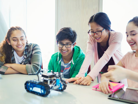 Students programming and testing robotics in classroom