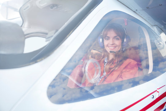 Portrait smiling female airplane pilot in cockpit