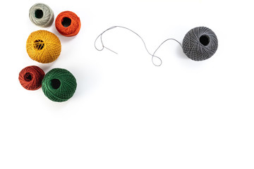 Embroidery accessories. Multicolored bundles of thread, scissors, sewing needles. White background...