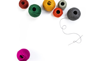 Embroidery accessories. Multicolored bundles of thread, scissors, sewing needles. White background...