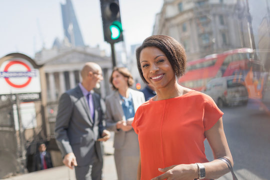 Portrait smiling businesswoman on sunny urban city street, London, UK