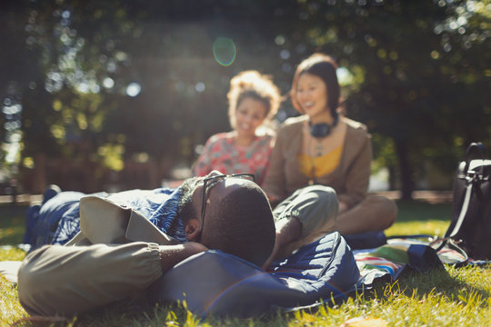 Young friends relaxing in sunny summer park