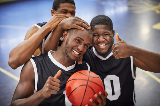 Portrait smiling, confident young male basketball player team celebrating, gesturing thumbs-up