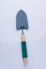 Garden trowel isolated on white background. Green handle, tool for gardening or masonry.