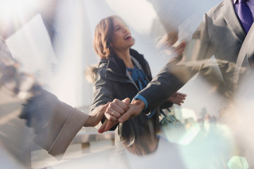 Smiling businesswoman behind handshaking business people