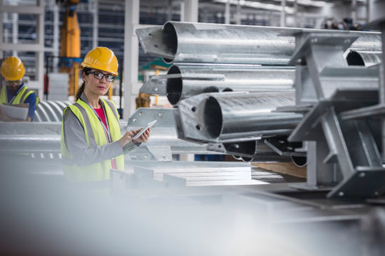 Portrait confident female worker with digital tablet in steel factory