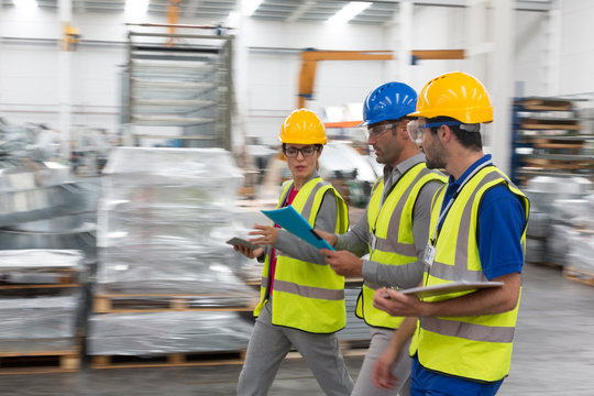 Supervisor and workers walking and talking n warehouse